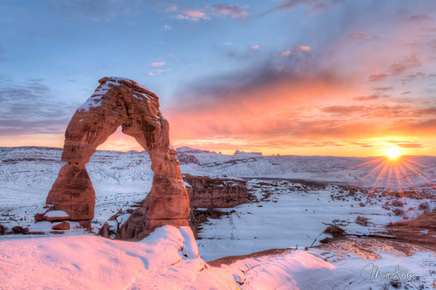 Snowy Delicate Arch At Sunset