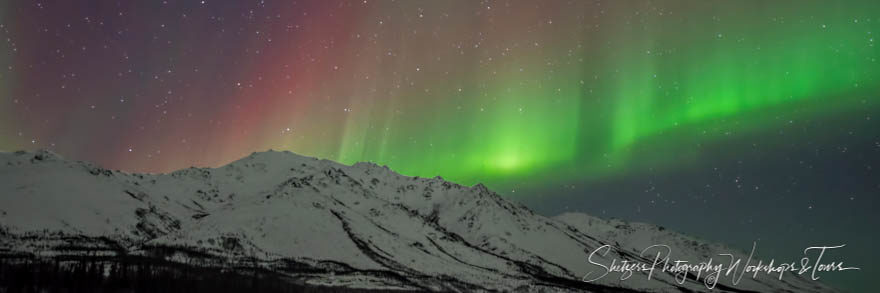 Long stretching northern lights along mountain horizon