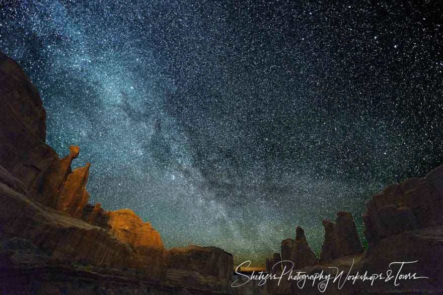 Milky way lights up Park Avenue in Arches National Park.