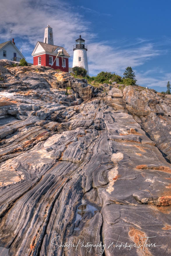 Pemaquid Point Light with rocky foreground and blue sky