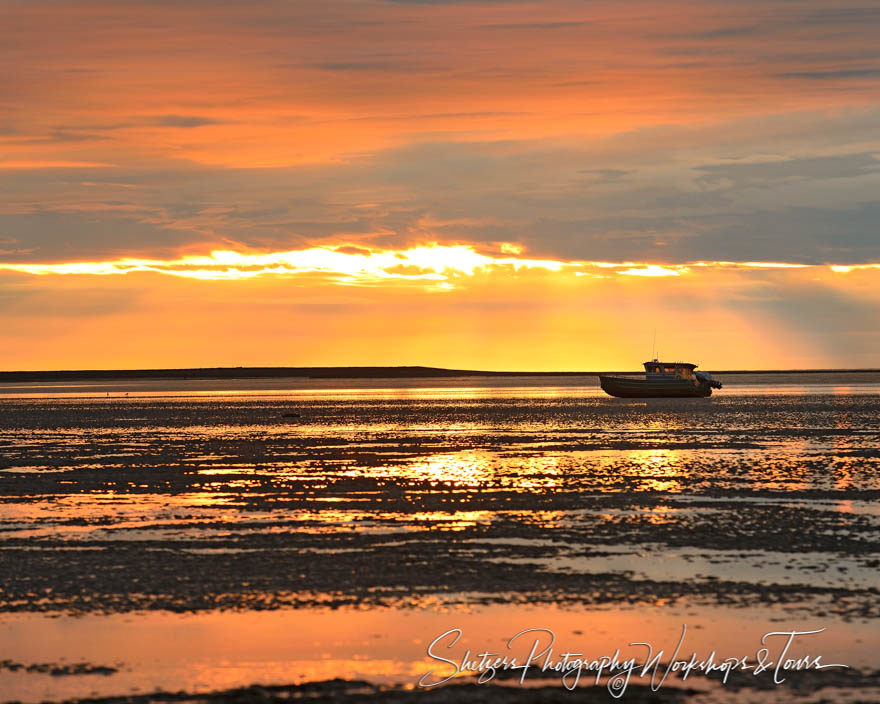 Scenic image of sunlit beach and sky with boat