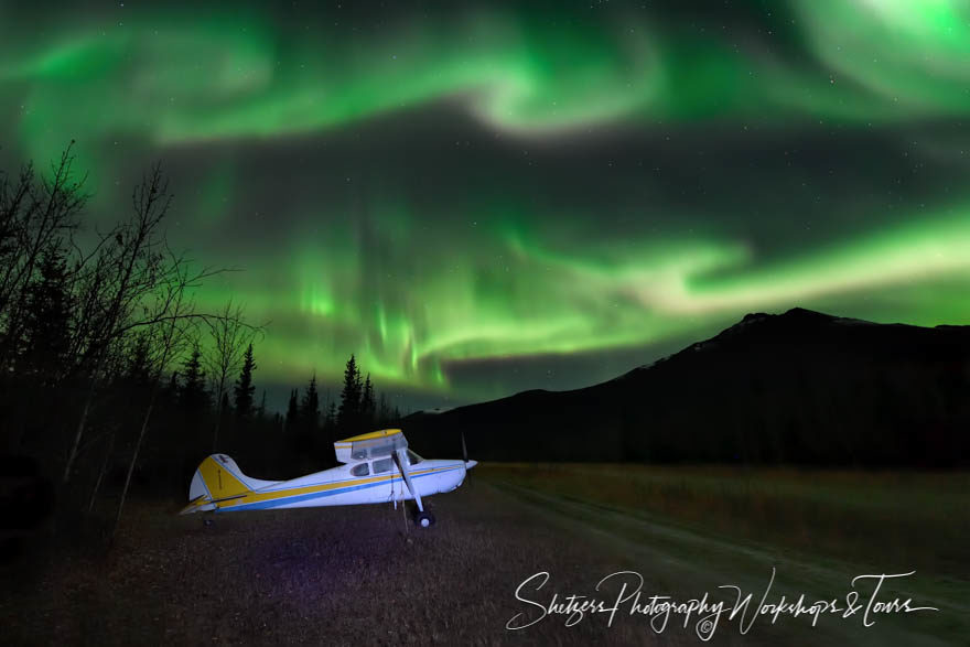 A Cessna aircraft illuminated by the Auroa Borealis